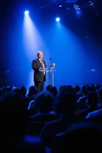 Séminaire communication charismatique - dirigeant prenant la parole sur scène devant un auditoire